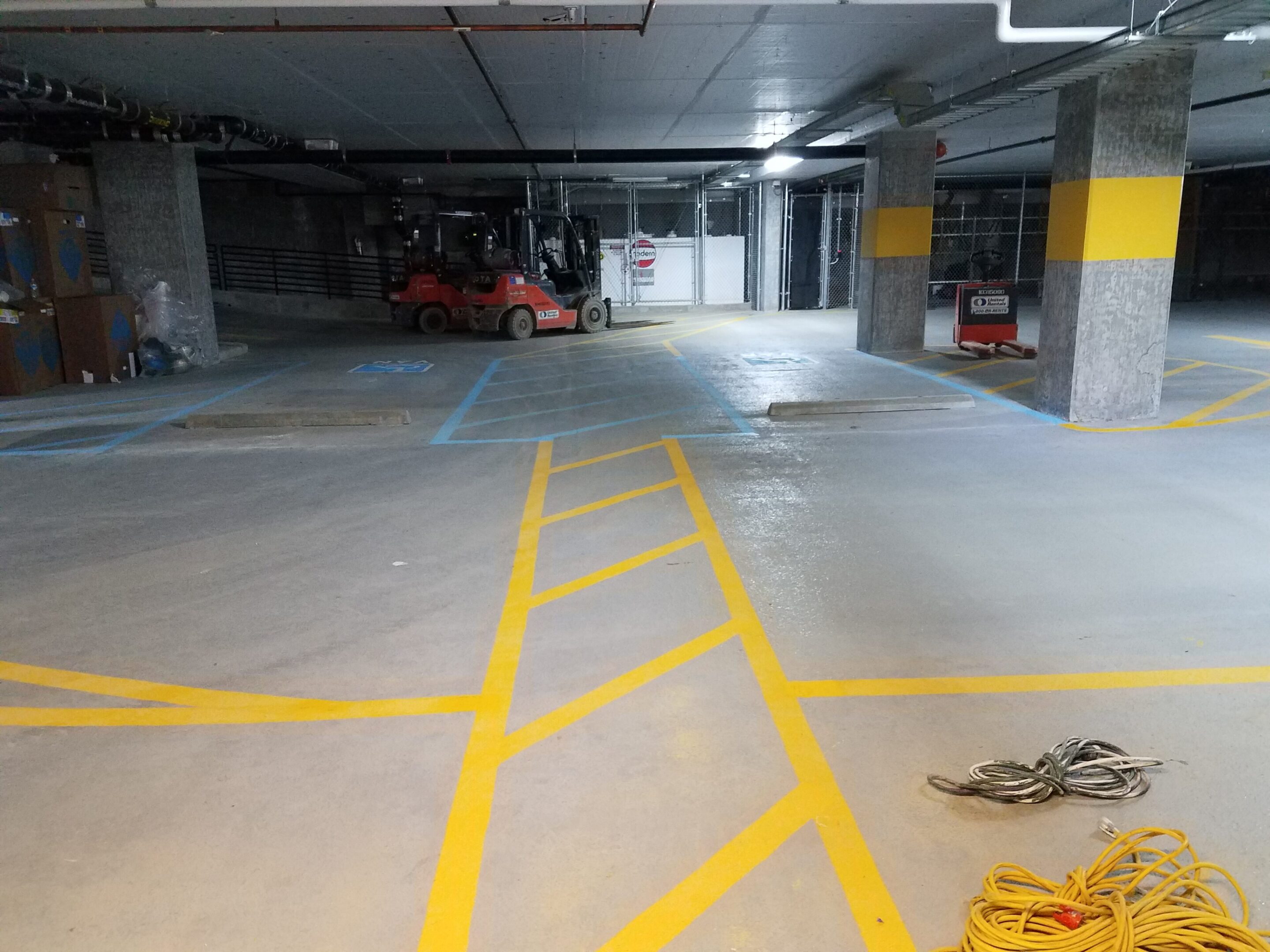 Empty parking garage area with yellow markings on the floor.