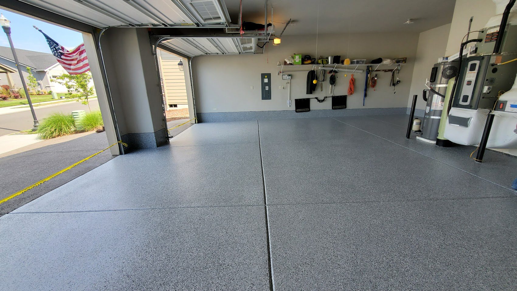 Clean, spacious garage with polished concrete floor and organized shelves.