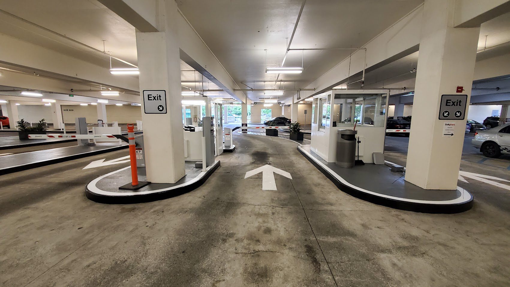 Empty indoor parking garage with clear directional arrows and exit signs.
