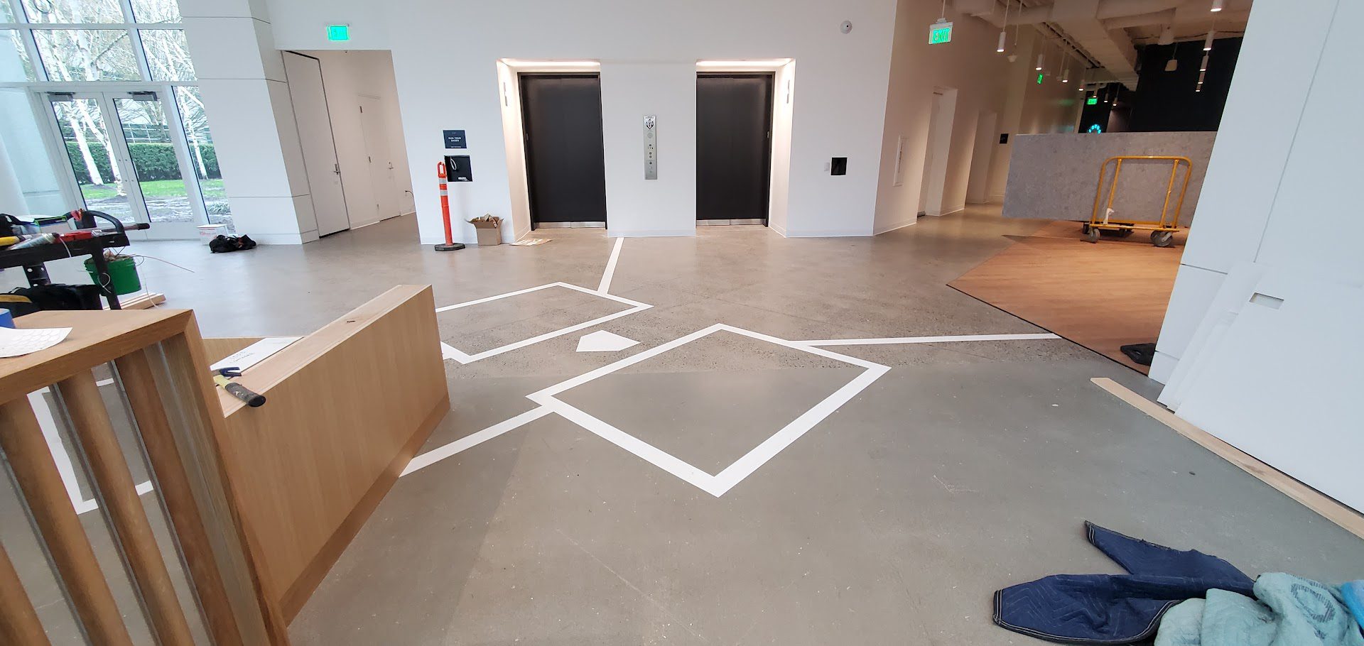 Geometric white line art on a polished concrete floor in a modern gallery space.