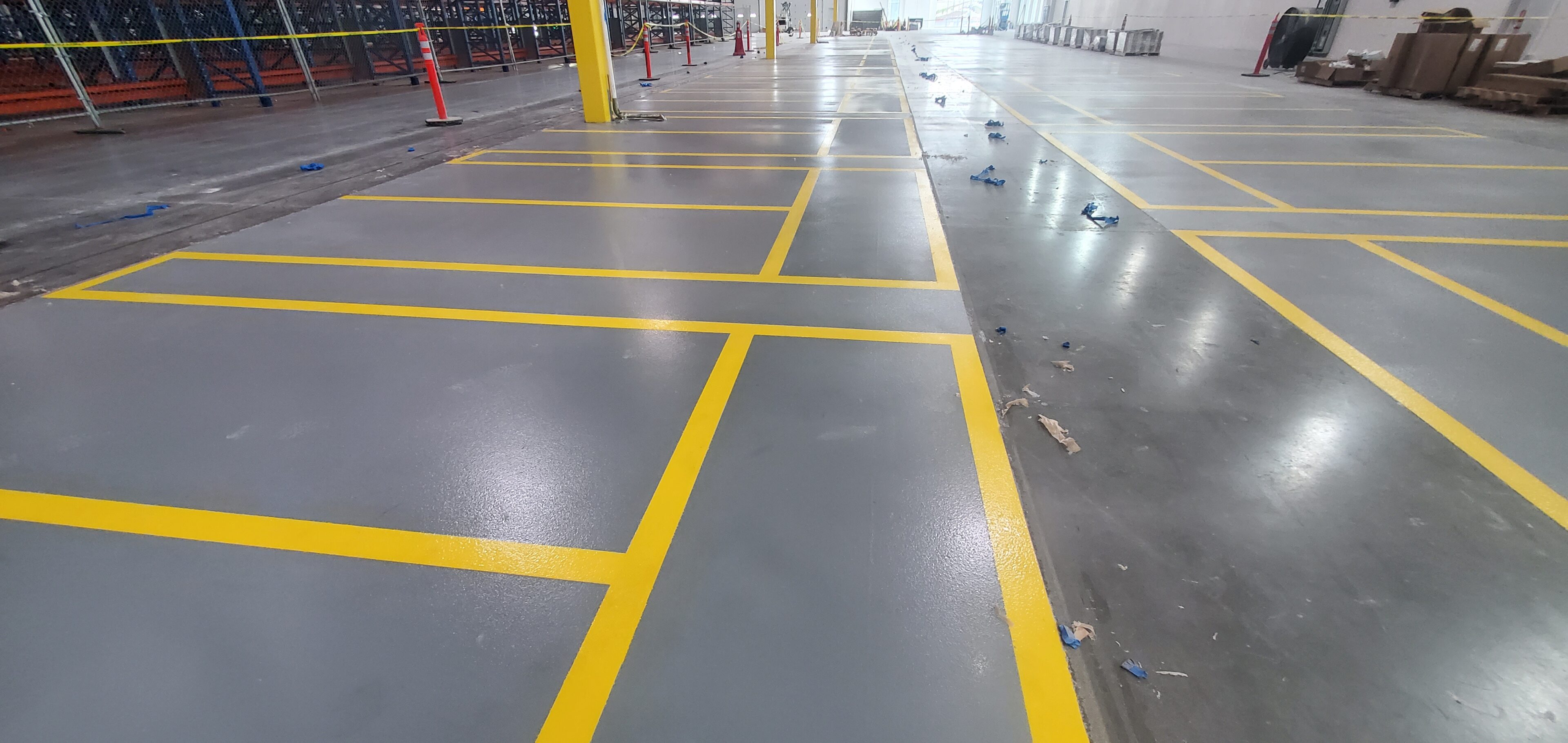 Freshly painted yellow parking lines on a smooth concrete floor.