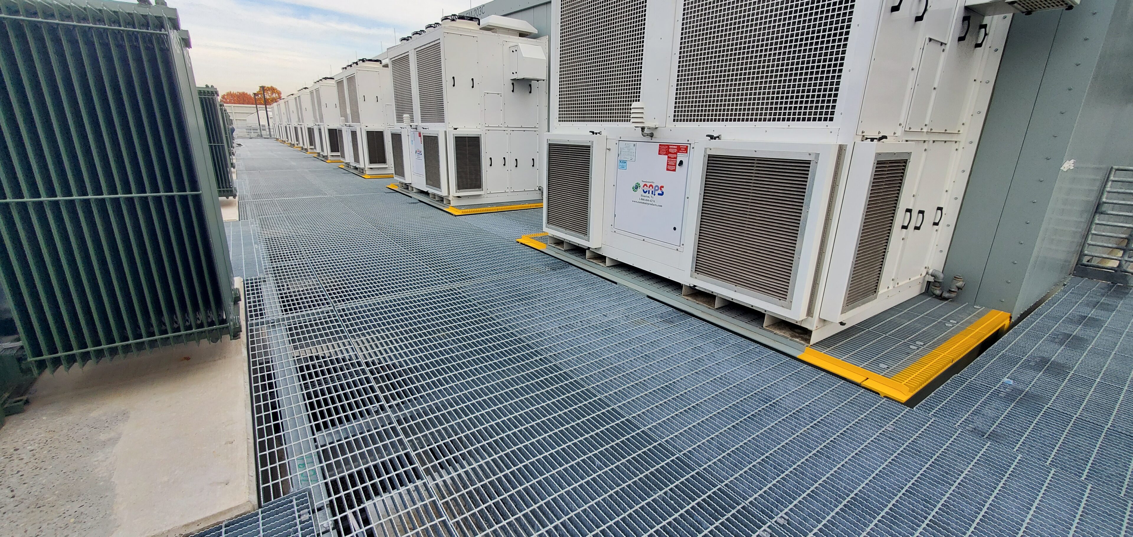 Modern HVAC units installed on a rooftop with protective metal grating.
