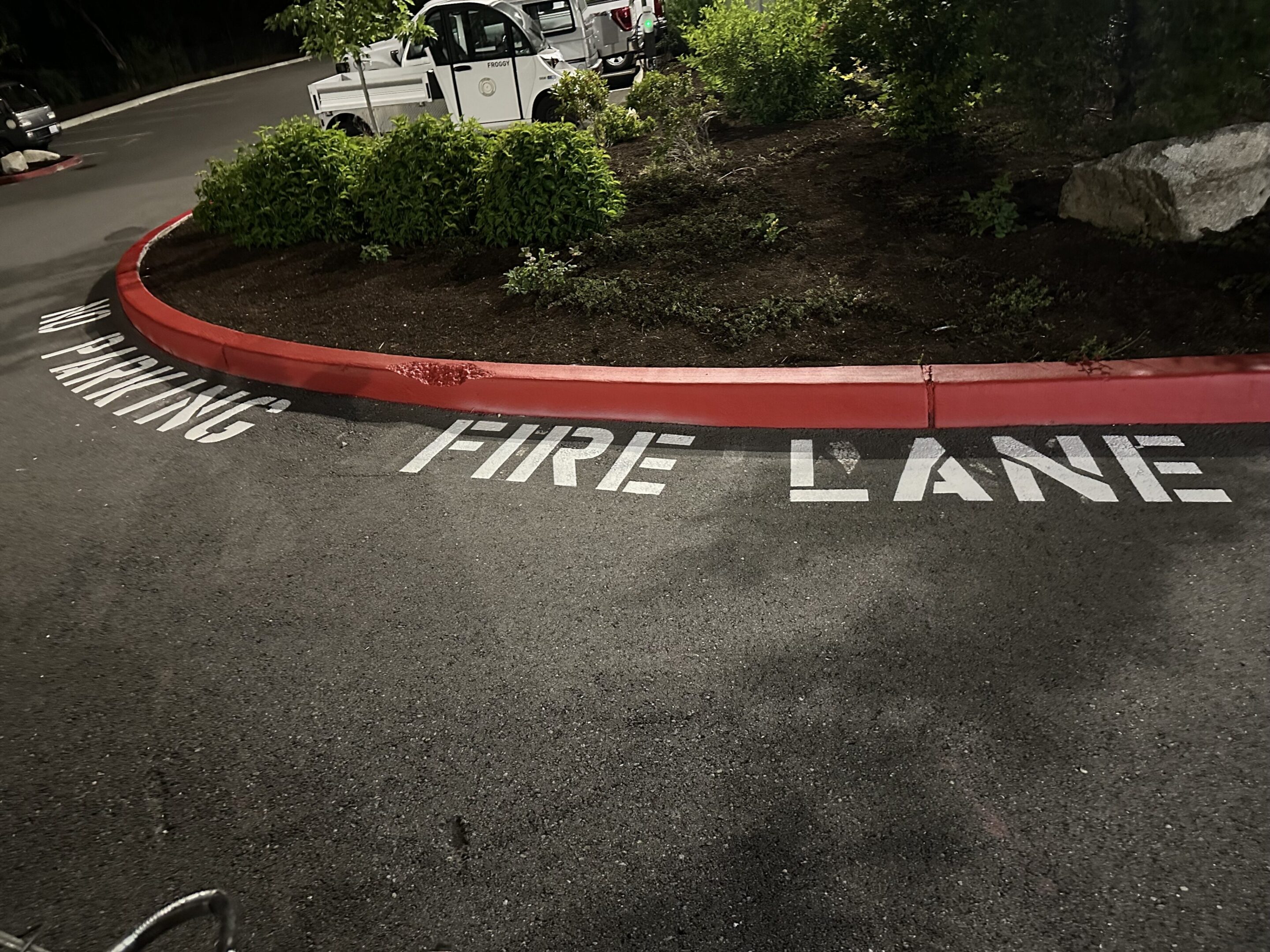 Red curb marked as a fire lane with white painted letters.