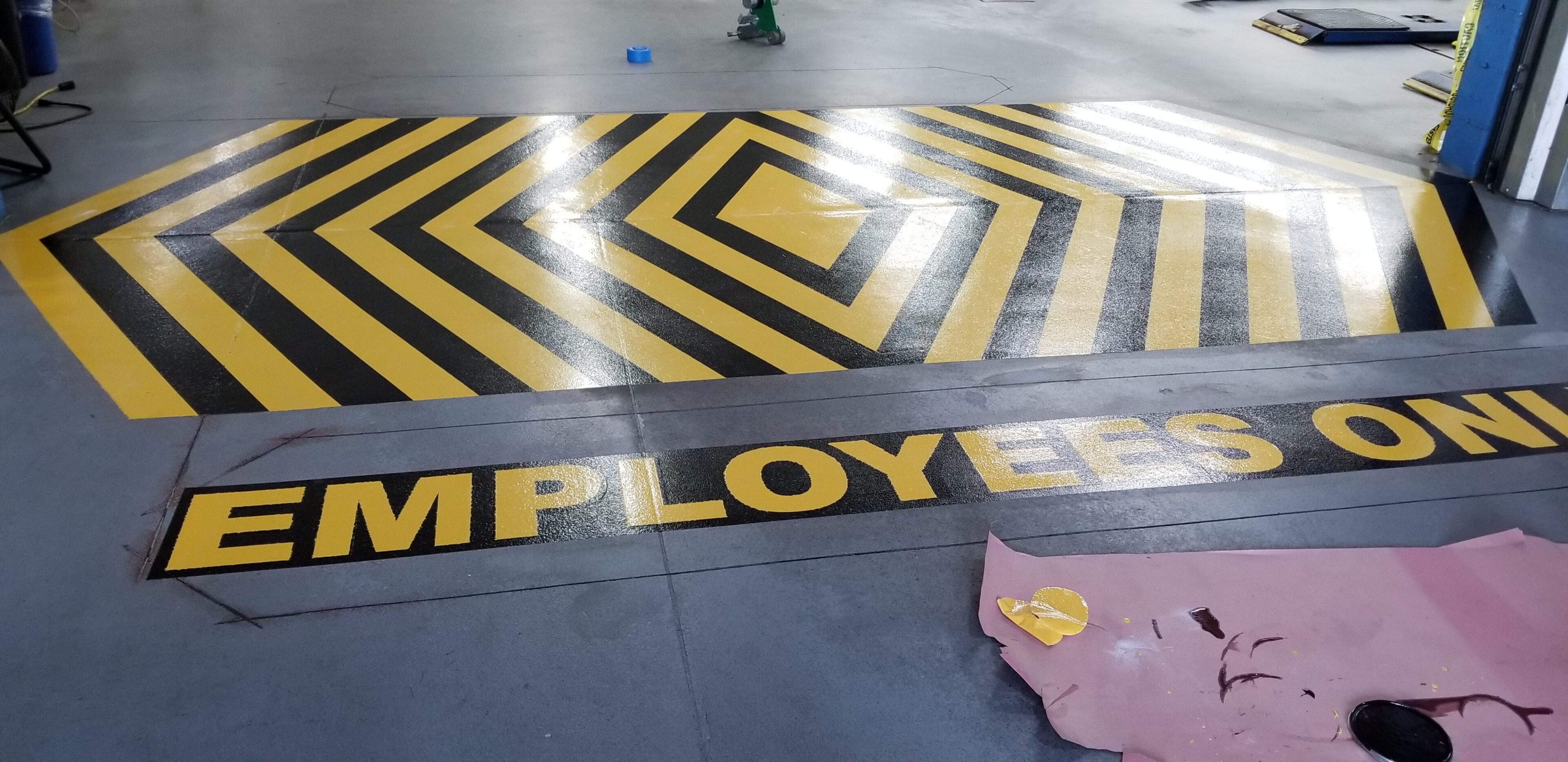 Yellow and black striped floor marking with the word 'EMPLOY' partially visible.